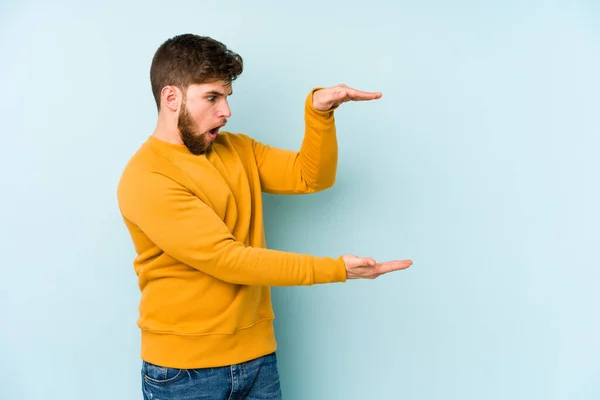 Junge Kaukasische Mann Isoliert Auf Blauem Hintergrund Schockiert Und Erstaunt — Stockfoto