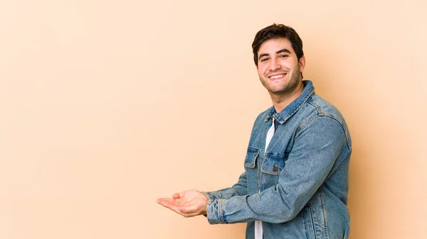 Jongeman Geïsoleerd Beige Achtergrond Met Een Kopieerruimte Een Palm — Stockfoto