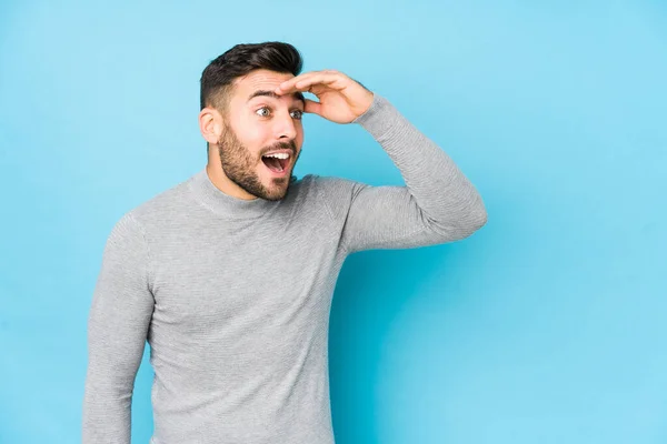 Joven Hombre Caucásico Sobre Fondo Azul Aislado Mirando Lejos Manteniendo —  Fotos de Stock