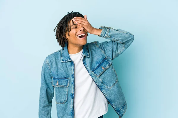 Kot ceket giyen genç siyahi adam ellerini başının üstünde tutarak neşe içinde gülüyor. Mutluluk kavramı.