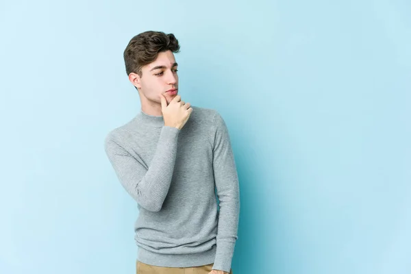 Jonge Blanke Man Geïsoleerd Blauwe Achtergrond Kijken Zijwaarts Met Twijfelachtige — Stockfoto