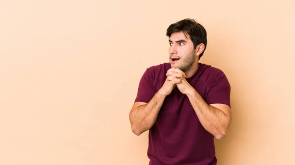 Young Man Isolated Beige Background Praying Luck Amazed Opening Mouth — Stock Photo, Image