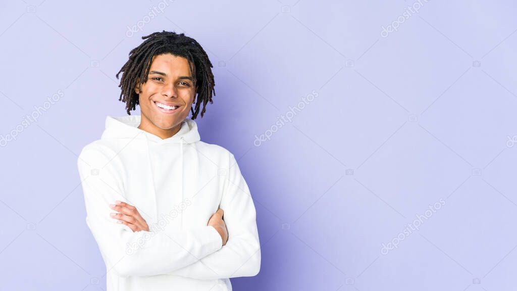 Young african american rasta man who feels confident, crossing arms with determination.