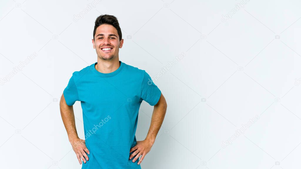 Young caucasian man isolated on white background confident keeping hands on hips.