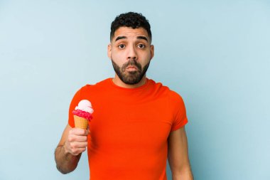 Dondurma tutan genç bir latin omuz silkiyor ve gözleri açık..