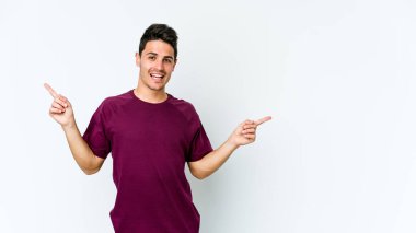 Beyaz arka planda izole edilmiş genç beyaz bir adam farklı kopya alanlarını gösteriyor, birini seçiyor, parmaklarıyla gösteriyor..