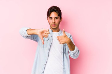 Pembe arka planda poz veren beyaz bir genç. Kendini soyutlamış. Onaylıyor ve onaylıyor.