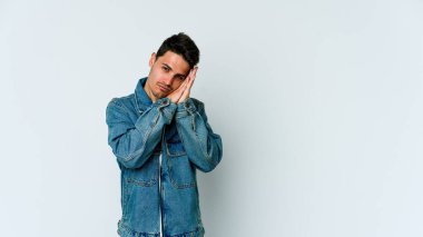 Beyaz arka planda izole edilmiş genç beyaz adam esniyor. Ağzı eliyle kapatan yorgun bir hareket sergiliyor..