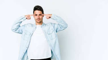 Beyaz arka planda izole edilmiş genç beyaz bir adam bir göreve odaklanmış, işaret parmaklarını işaret ediyor..