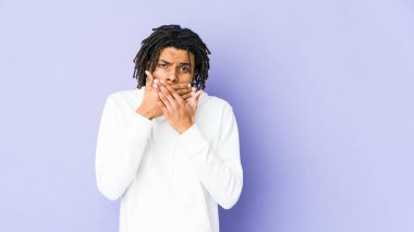 Genç Afro-Amerikan Rasta adam elleri ve ağzı kapalı endişeli görünüyor..