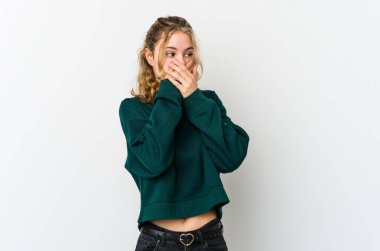 Beyaz arka plandaki genç beyaz kadın. Elle ağzını kapatan bir fotokopi odasına bakıyor..