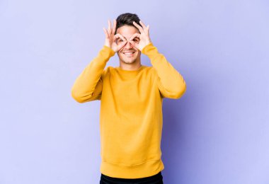 Mor arka planda izole edilmiş genç beyaz adam gözlerinde sorun olmadığını gösteriyor.