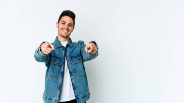 Beyaz arka planda soyutlanmış beyaz tenli genç adam öne bakan neşeli gülümsemeler..