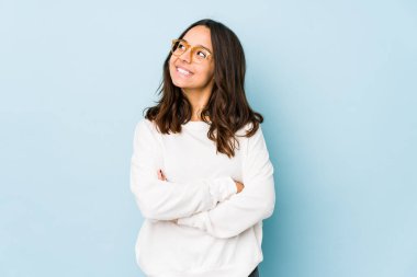 Genç, melez İspanyol kadın kendini soyutlamış, kollarını kavuşturarak gülümsüyor..