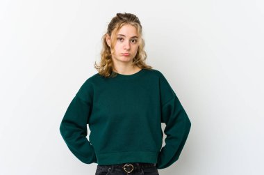 Beyaz arka plandaki genç beyaz kadın üzgün, ciddi yüz, mutsuz ve hoşnutsuz..