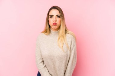 Soyutlanmış geçmişi olan orta yaşlı bir kadın yanakları patlatır, yorgun bir ifadeye sahiptir. Yüz ifadesi kavramı.