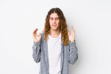 Uzun saçlı genç adam neşeli bir şekilde gülüyor. Mutluluk kavramı.