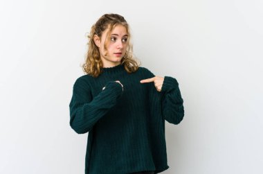 Beyaz arka plandaki genç beyaz kadın parmağını gösterip gülümseyerek şaşırdı..