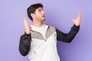 Mor arka planda izole edilmiş genç adam gökyüzüne haykırıyor, yukarı bakıyor, hayal kırıklığına uğramış..