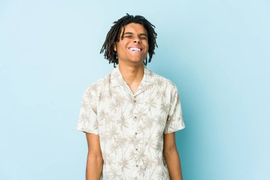 Genç Afrikalı Amerikalı Rasta adam gülüyor ve gözlerini kapıyor, rahatlamış ve mutlu hissediyor..