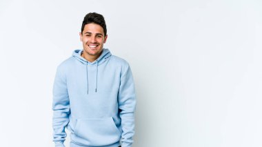 Beyaz arka planda izole edilmiş genç beyaz adam gülüyor ve gözlerini kapıyor, rahatlamış ve mutlu hissediyor..