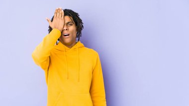 Genç Afrikalı Amerikalı Rasta adam bir şeyi unutuyor. Alnına avuç içi ve gözlerini kapatıyor..