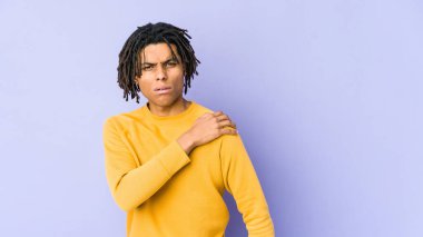 Rasta saç stili giyen genç siyahi adamın omuz ağrısı var..