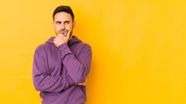 Kafkasyalı genç adam sarı fırında izole edilmiş şüpheli ve şüpheci bir ifadeyle yana bakıyor..