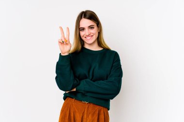 Beyaz arka planda izole edilmiş genç beyaz kadın iki numarayı parmaklarıyla gösteriyor..