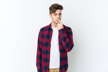 Beyaz arka planda soyutlanmış genç beyaz bir adam düşünüyor ve yukarı bakıyor, yansıtıyor, düşünüyor, hayal kuruyor..