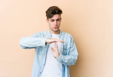 Beyazlı genç bir adam bej arka planda izole edilmiş..