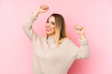 Orta yaşlı bir kadın özel bir günü kutluyor, kollarını enerji ile kaldırıyor..