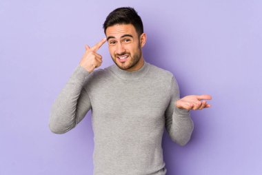 Mor arka planda izole edilmiş genç beyaz adam işaret parmağıyla hayal kırıklığı jesti gösteriyor..