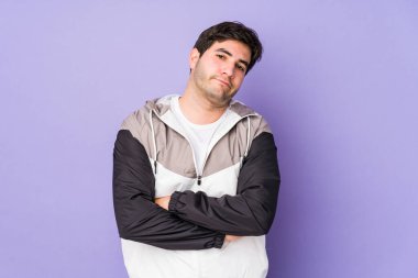 Mor arka planda izole edilmiş, sıkılmış, yorgun ve dinlenmeye ihtiyacı olan genç bir adam..