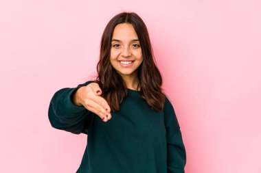 Latin kökenli genç bir kadın kameraya el uzatarak selam veriyor..