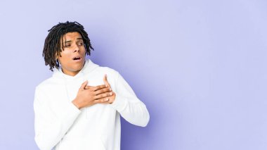 Genç Afro-Amerikan Rasta Adam 'ın dost canlısı bir ifadesi var. Avuçlarını göğsüne bastırıyor. Aşk konsepti.