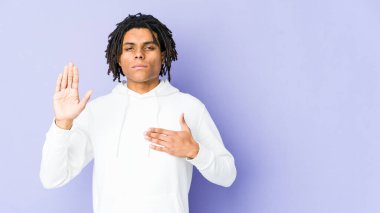 Genç Afrikalı Amerikalı Rasta adam yemin ediyor, elini göğsüne koyuyor..