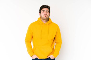 Beyaz arka planda izole edilmiş genç adamın yanakları şişer, yorgun bir ifadesi vardır. Yüz ifadesi kavramı.