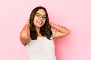 Genç, melez İspanyol kadın kendini soyutlamış, kendinden emin, elleri başının arkasında..