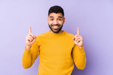 Genç, melez, Arap bir adam izole edilmiş, iki parmağı da havada, boş bir alan gösteriyor..