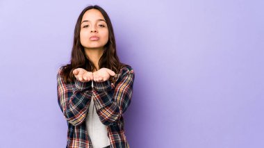 Latin kökenli genç bir kadın avuçlarıyla bir şey tutup kameraya sunuyor..