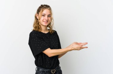 Beyaz arka plandaki genç beyaz kadın palmiye ağacında bir kopya alanı tutuyor..