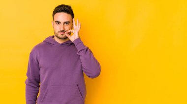 Sarı fırında izole edilmiş genç beyaz bir adam parmakları dudaklarında bir sır saklıyor..