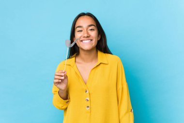 Genç Hintli kadın eğleniyor ve parti objelerini soyutluyor.