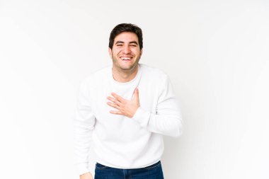 Beyaz arka planda izole genç adam kahkahalar atıyor elini göğsüne koyuyor..