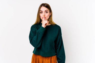 Beyaz arka planda izole edilmiş genç beyaz kadın ya sır saklıyor ya da sessizlik istiyor..