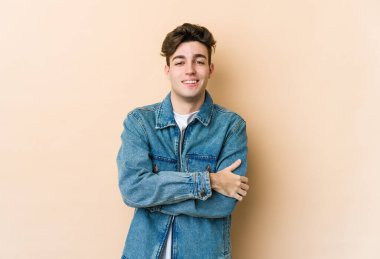 Beyazların arka planında izole edilmiş genç, kendinden emin, kararlılıkla kollarını kavuşturan bir adam..