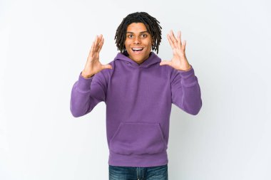 Genç Afrikalı Amerikalı Rasta adam hoş bir sürpriz alıyor, heyecanlı ve el kaldırıyor..