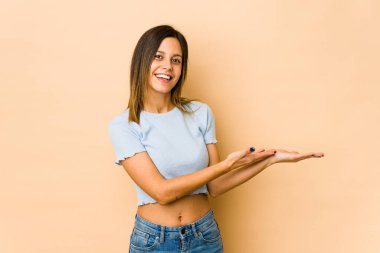 Bej arka planda izole edilmiş genç bir kadın avucunun içinde bir kopya alanı tutuyor..