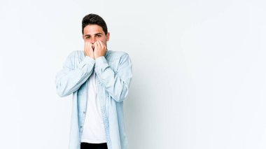 Beyaz arka planda izole edilmiş, tırnak yiyen, gergin ve endişeli genç bir beyaz adam..